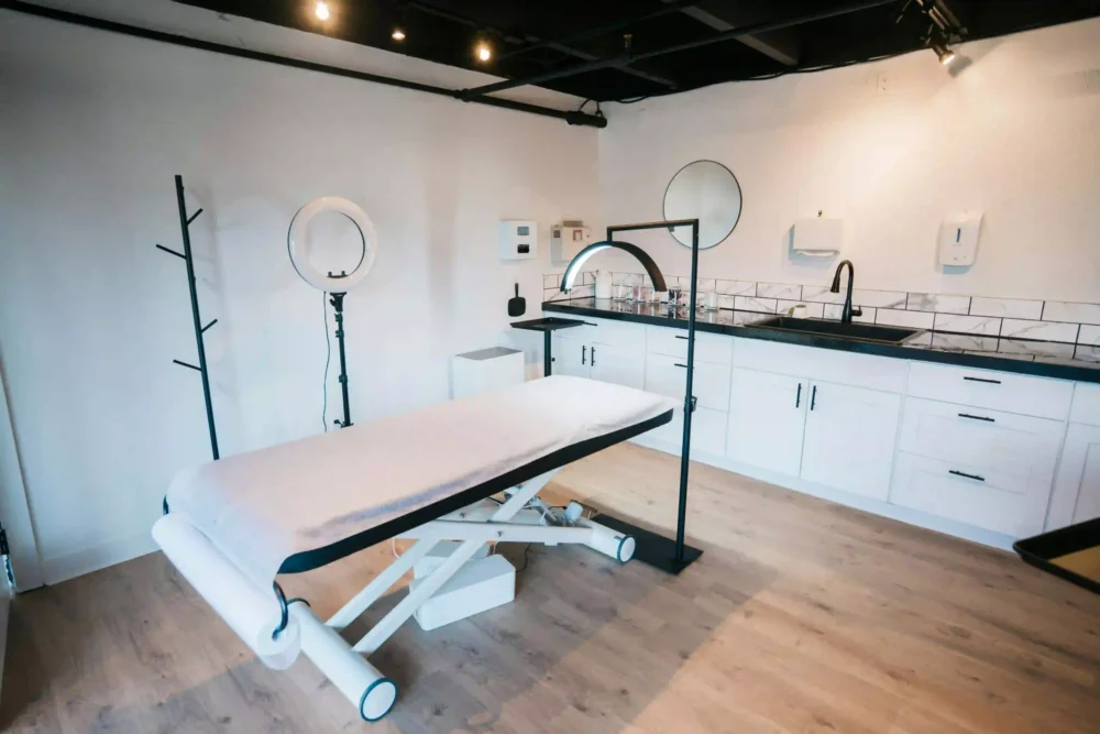 Vista interior de una cabina de estética moderna y limpia, con camilla profesional y equipo esterilizado para presoterapia